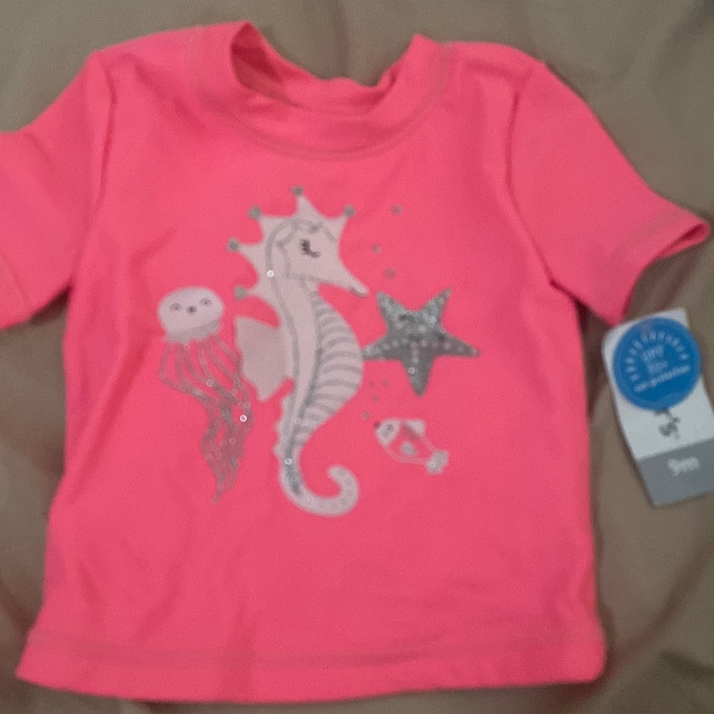 Selling a swim shirt.The Brand is Carters. The color is pink with a sea horse.